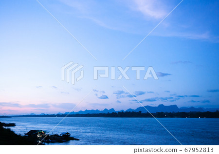 Blue tone sunset sky over Mae Khong river in Thailand - Nakhon Phanom Blue tone sunset sky over Mae Khong river in Thailand - Nakhon Phanom 67952813