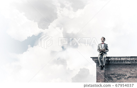 Young businessman or student studying the science on building roof Young businessman or student studying the science on building roof 67954037