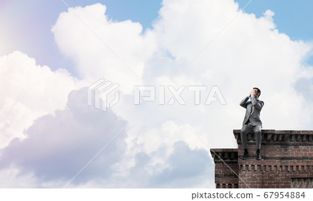 Young man on building edge do not want to see anything Young man on building edge do not want to see anything 67954884