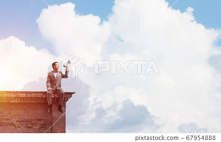Businessman or manager on building roof announcing something in loudspeaker Businessman or manager on building roof announcing something in loudspeaker 67954888
