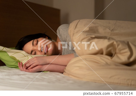 A woman sleeping in bed 67955714