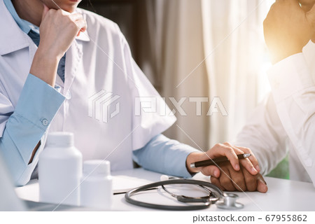 Friendly female doctor hands holding patient hand sitting at the desk for encouragement, empathy, cheering and support while medical examination. Friendly female doctor hands holding patient hand sitting at the desk for encouragement, empathy, cheering and support while medical examination. 67955862