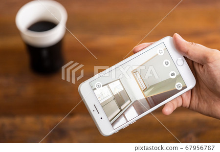 Hands of people who are looking inside real estate on a smartphone (online preview image) 67956787