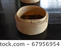 A Cylindrical wooden basket for adding dim sum on dark brown table 67956954