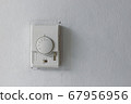 A white switch and termostat for controling air conditioner on the old white wall in patient room of a hospital in Bangkok 67956956
