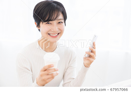 Woman looking at smartphone drink 67957066