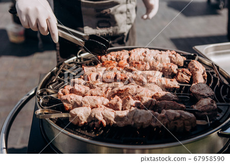 chef prepares meat charcoal grill outside party 67958590