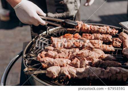 chef prepares meat charcoal grill outside party 67958591