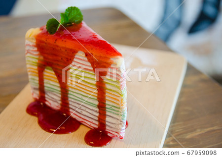 close up of rainbow crepe cake on wooden plate close up of rainbow crepe cake on wooden plate 67959098