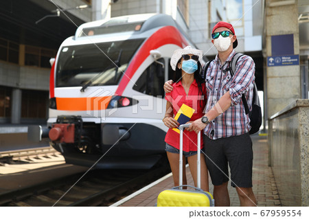 Family stands next to a train waiting for boarding Family stands next to a train waiting for boarding 67959554