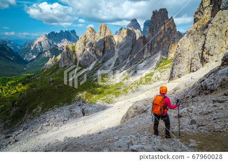 Woman hiker with backpack on the hiking trail, Dolomites, Italy Woman hiker with backpack on the hiking trail, Dolomites, Italy 67960028
