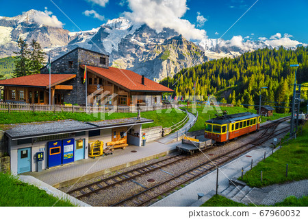 Railway station with mountains and retro tourist train, Murren, Switzerland Railway station with mountains and retro tourist train, Murren, Switzerland 67960032