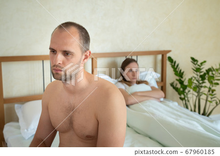 Upset man sitting in bed, sexual problems concept Upset man sitting in bed, sexual problems concept 67960185