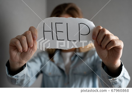 Woman depressed expression and showing a paper with a help text. Violence against women Woman depressed expression and showing a paper with a help text. Violence against women 67960868