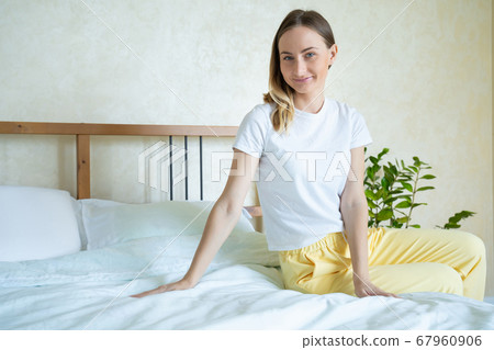 Woman is touching very soft and clean bed linen. 67960906