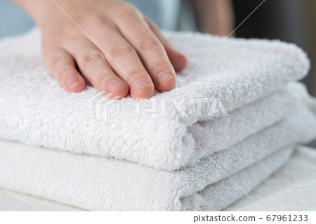 A woman touches a fresh white towel 67961233