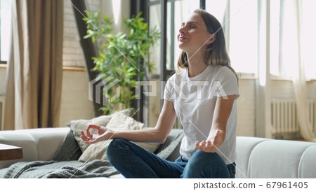 Attractive young woman exercising and sitting in yoga lotus position  67961405