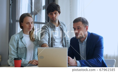 Young business people working with laptop and talking of they new project together in the office. 67961585