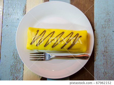 banana crape cake on white plate on wooden table 67962152