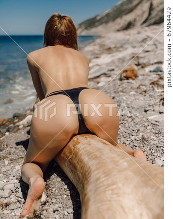 Sexy slim woman in bikini posing at sea beach Stock Photo