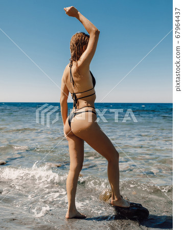 Woman in bikini posing on beach Stock Photo