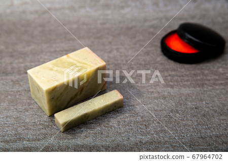 A stone carved seal with a sword. Stone carving and vermilion. A seal, seal, or signature to be stamped on a document. 67964702