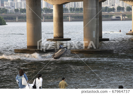 A person performing tricks on a jet boat on the Han River A person performing tricks on a jet boat on the Han River 67964737