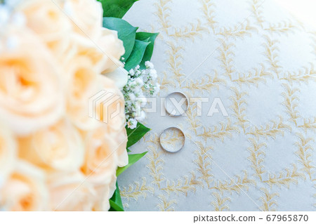 Beautiful wedding rings lie on light surface Beautiful wedding rings lie on light surface 67965870