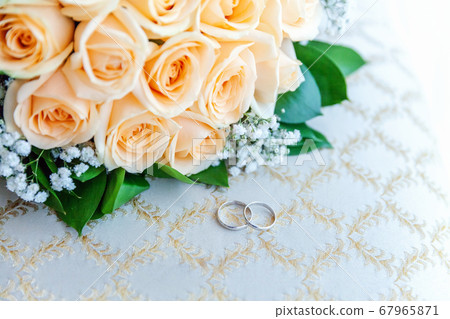 Beautiful wedding rings lie on light surface Beautiful wedding rings lie on light surface 67965871