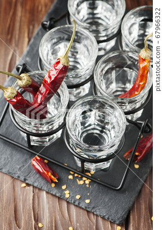 Glasses of vodka with hot chili peppers Glasses of vodka with hot chili peppers 67966322