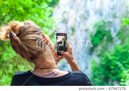 nature photography with the help of a smartphone by a young tourist on a trip 67967276