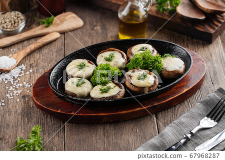 Baked stuffed champignon hats in a pan  67968287