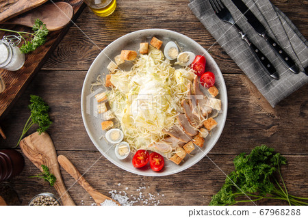 Caesar salad with chicken on the wooden table Caesar salad with chicken on the wooden table 67968288
