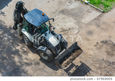 Tractor with bucket for excavation work during road construction 67969009