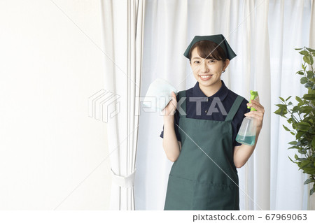 Female worker in house cleaning with detergent and towel 67969063