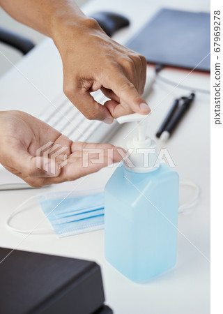 man at work disinfecting his hands 67969278