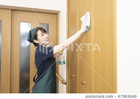 Rear view of a female worker cleaning the door cleaning the house Rear view of a female worker cleaning the door cleaning the house 67969840