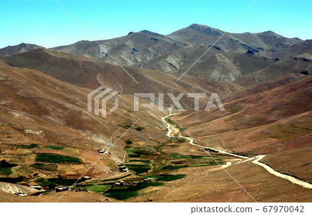 Mountain scenery between Kabul and Bamyan (Bamiyan) in Afghanistan. Dusty road to a remote village. Taken from the road on the southern route between Kabul and Bamyan (Bamiyan) in central Afghanistan. Mountain scenery between Kabul and Bamyan (Bamiyan) in Afghanistan. Dusty road to a remote village. Taken from the road on the southern route between Kabul and Bamyan (Bamiyan) in central Afghanistan. 67970042