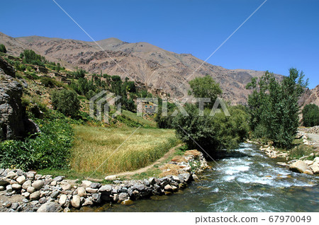 Village with local Afghan houses. Mountain scenery between Kabul and Bamyan (Bamiyan) in Afghanistan. Taken from the road on the southern route between Kabul and Bamyan (Bamiyan), central Afghanistan. 67970049