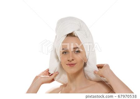 Beauty Day. Woman wearing towel doing her daily skincare routine. Portrait isolated on white studio background Beauty Day. Woman wearing towel doing her daily skincare routine. Portrait isolated on white studio background 67970538