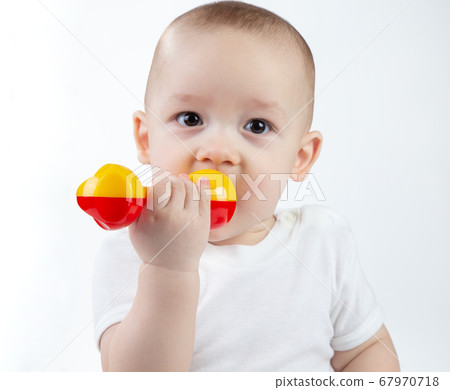 Portrait of a nine-month-old baby with rattle on a white background Portrait of a nine-month-old baby with rattle on a white background 67970718