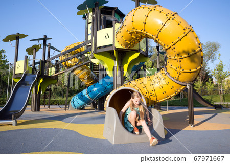 girl at the  large beautiful playground in the 67971667