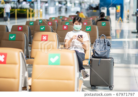 Young female wearing face mask and using mobile Young female wearing face mask and using mobile 67971797