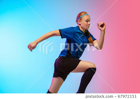 Female soccer, football player training in action isolated on gradient studio background in neon light 67972151