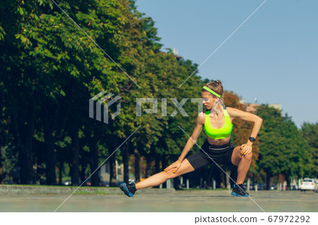 Female runner, athlete training outdoors in summer's sunny day. Female runner, athlete training outdoors in summer's sunny day. 67972292