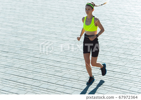 Female runner, athlete training outdoors in summer's sunny day. 67972364