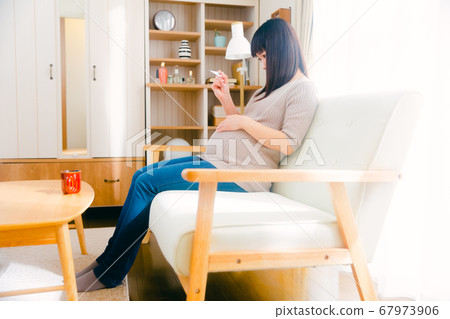 Pregnant woman measuring body temperature 67973906
