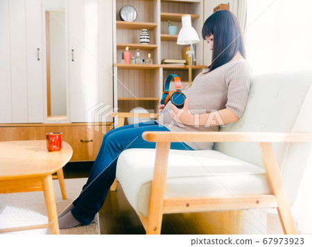 Pregnant woman with headphones on her stomach 4:3 67973923