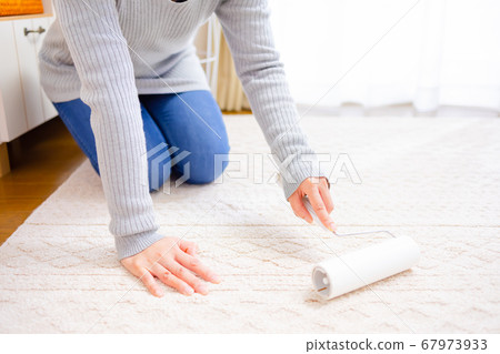 A woman applying an adhesive cleaner 67973933