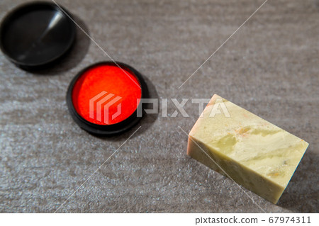 刻有劍的石刻印章。石雕和朱紅色。要在文件上蓋印的圖章,圖章或簽名。 刻有劍的石刻印章。石雕和朱紅色。要在文件上蓋印的圖章,圖章或簽名。 67974311